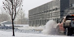 Pickup truck plowing snow outside a commercial building